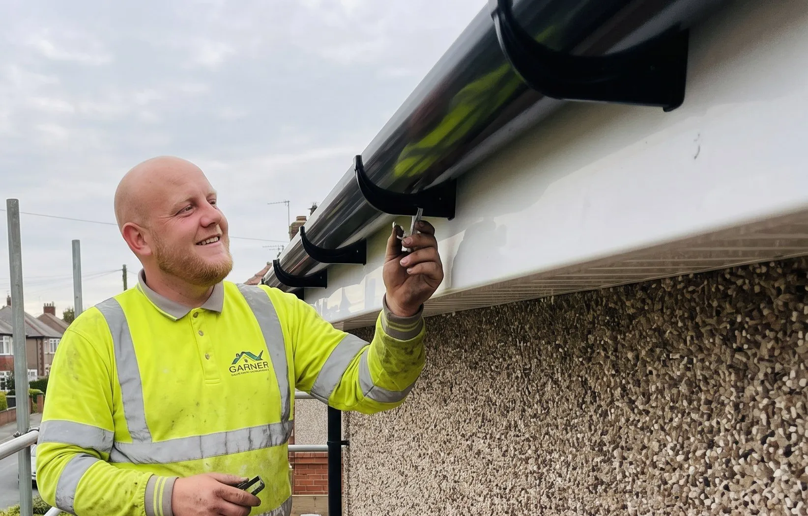 A new white uPVC fascia board and black gutter being fitted