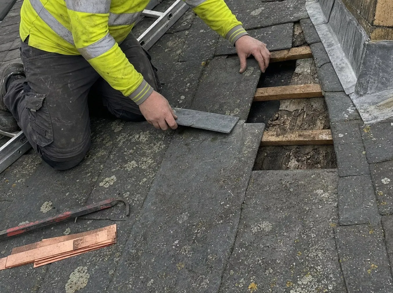 A replacement slate being slid into place with a slate ripper