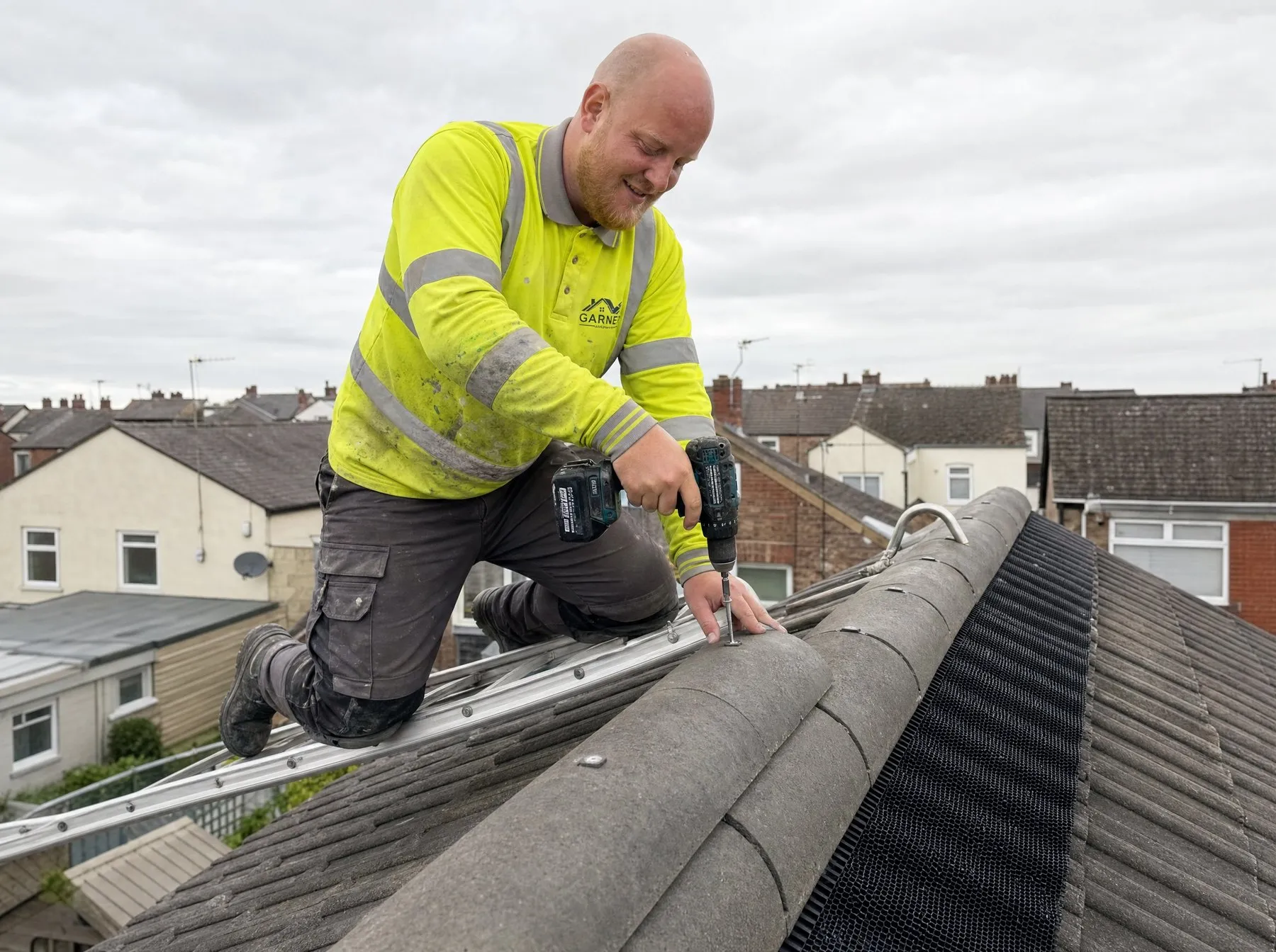 Jamie screwing down ridge tiles on a new dry ridge
