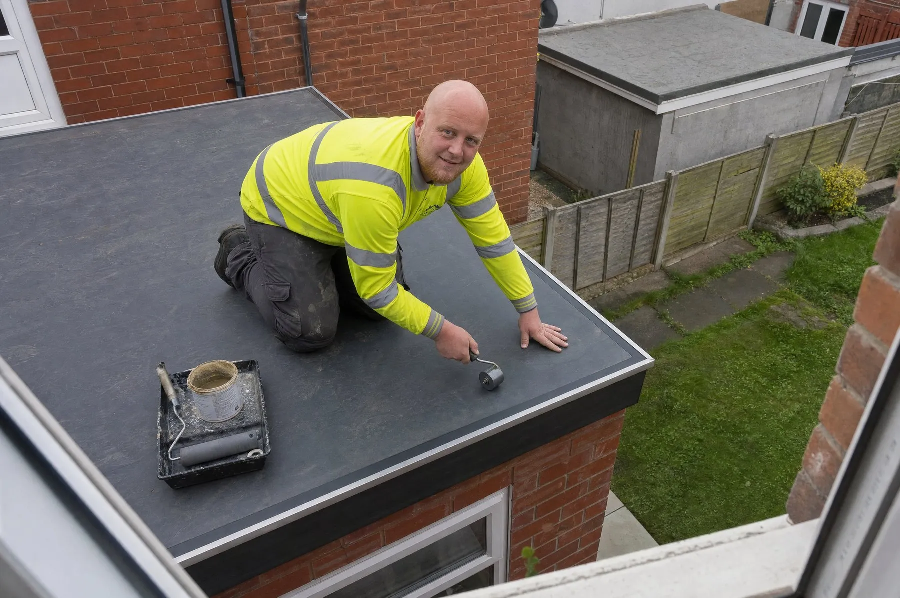 Jamie fitting a rubber membrane on a flat roof